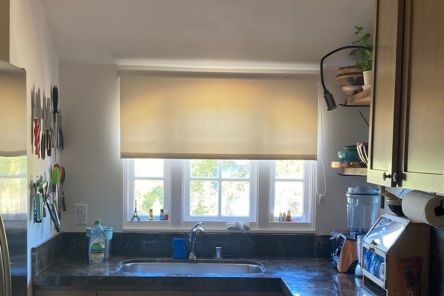 High quality roller shades half-lowered in Santa Clara kitchen window for light control